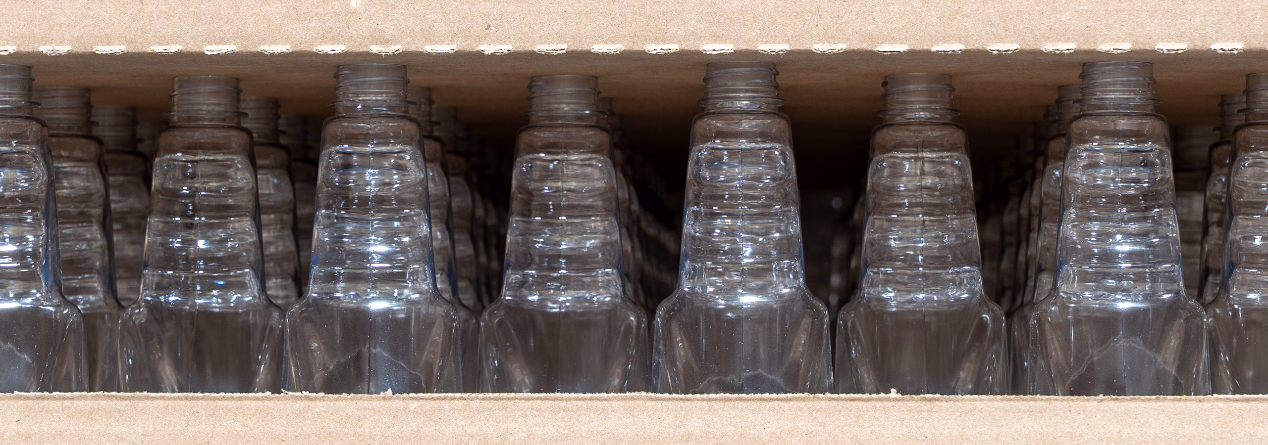 Empty, clear plastic bottles ready for product filling and contract bottling at Custom Bottling & Packaging.